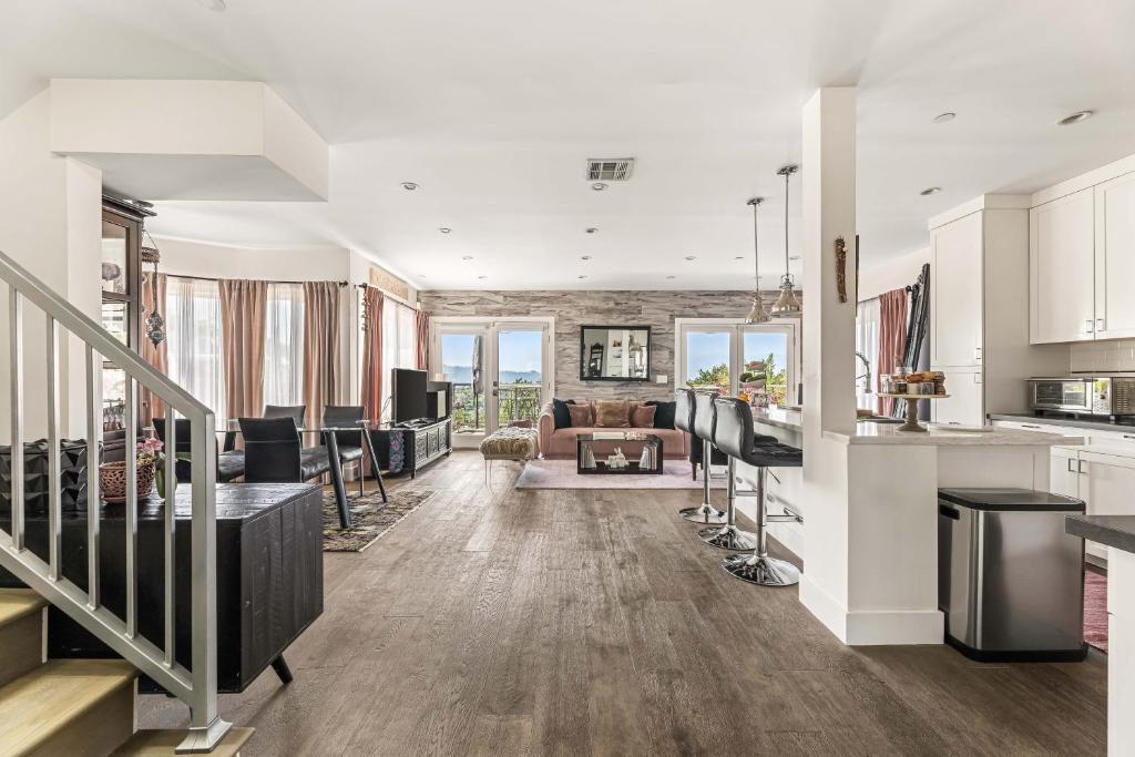 an open kitchen and living room with white walls and wood floors at Hilltop Escape-urban Oasis In Silverlakeecho Park in Los Angeles