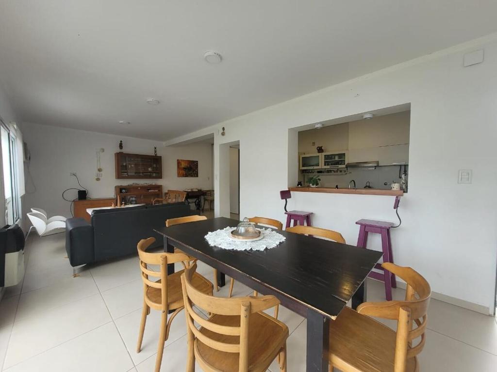 a dining room and living room with a table and chairs at Casa céntrica con piscina in Paraná