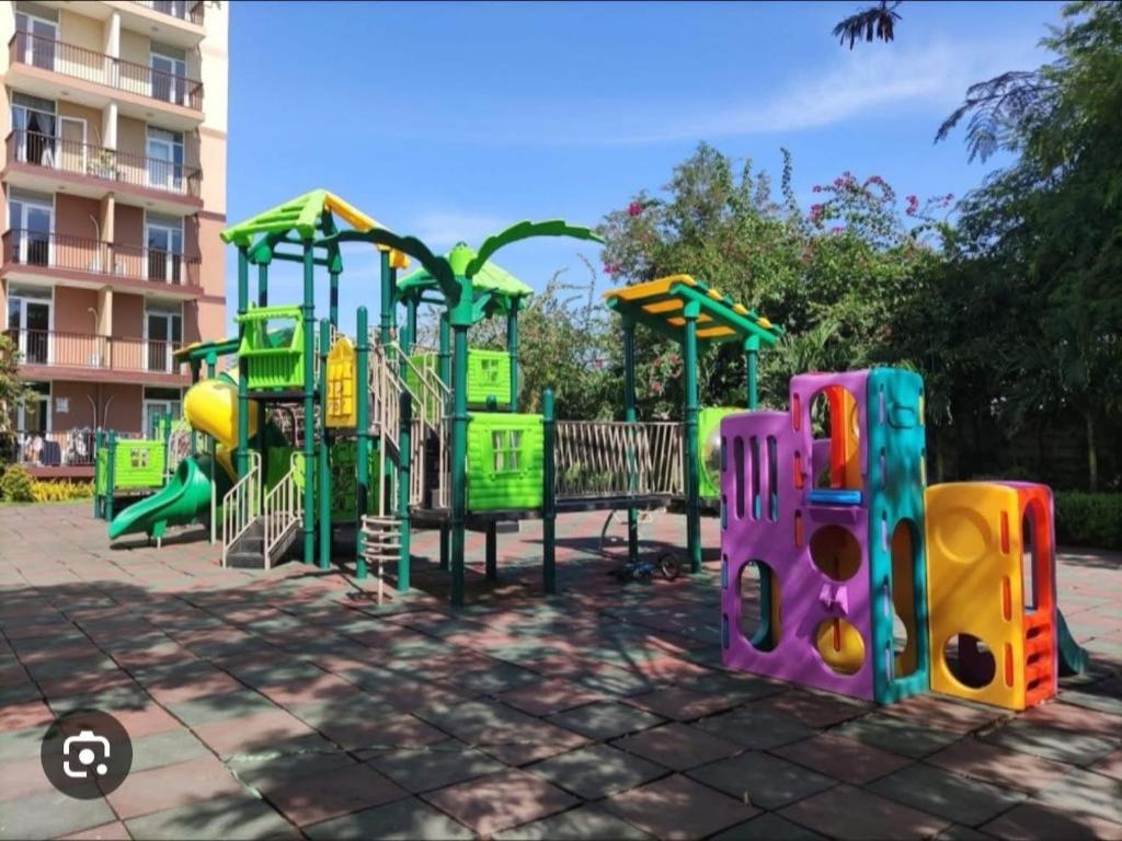 un parque infantil con equipo de juegos colorido frente a un edificio en Saekyung marigondon 2, en Suba