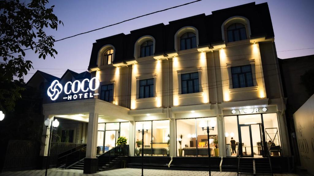 a building with a sign on the front of it at COCO Hotel Tashkent in Tashkent