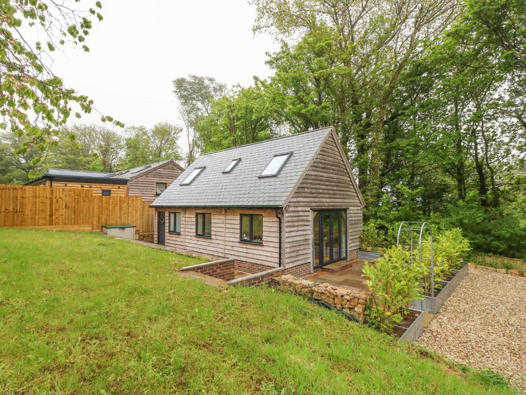 a small house in a backyard with a yard at Roman Lodge in Weymouth