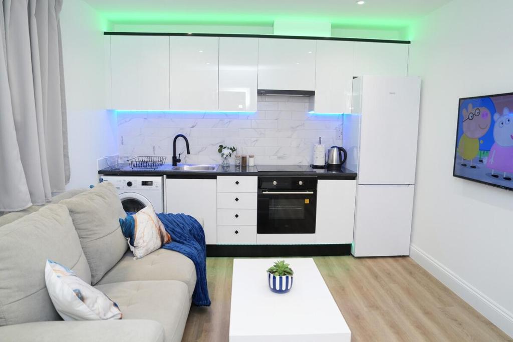 ミッチャムにあるLuxury 1 bed flat Londonの台所のソファに座る者