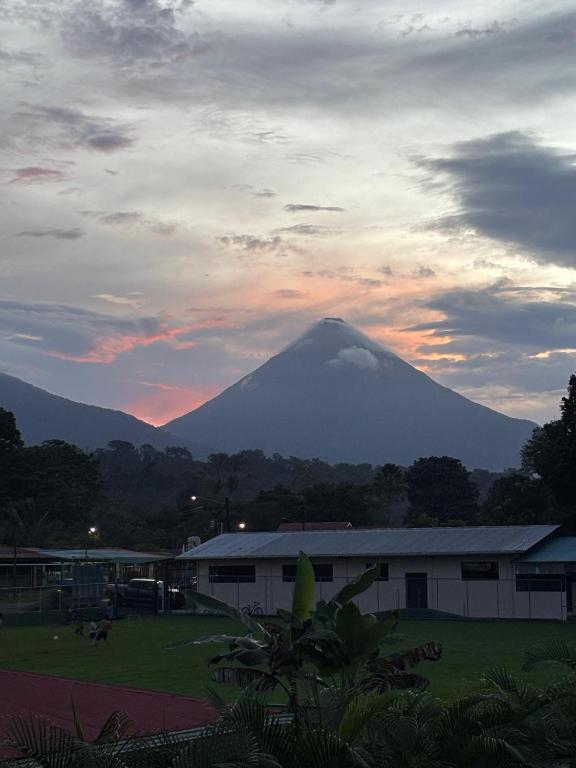 a mountain in the distance with a building and a sky at Sweet Dreams the Arenal in Fortuna
