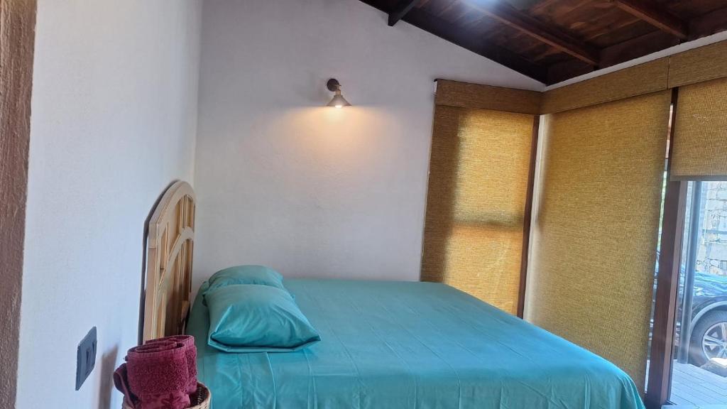 a bedroom with a bed with a blue blanket at Román Cabañas del Mirador Cabaña 1 in Pahuatlán del Valle