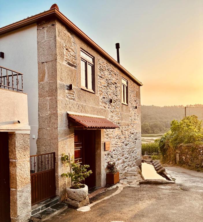 an old stone building with a door and a window at Casa do Caneiro in Vila Real