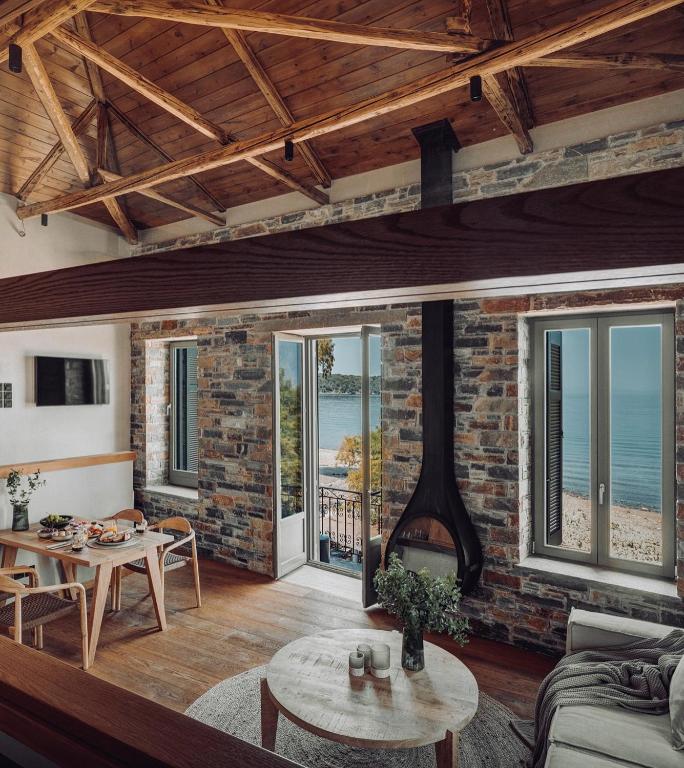 a living room with a brick wall and a fireplace at EJ Boutique Suites in Milina