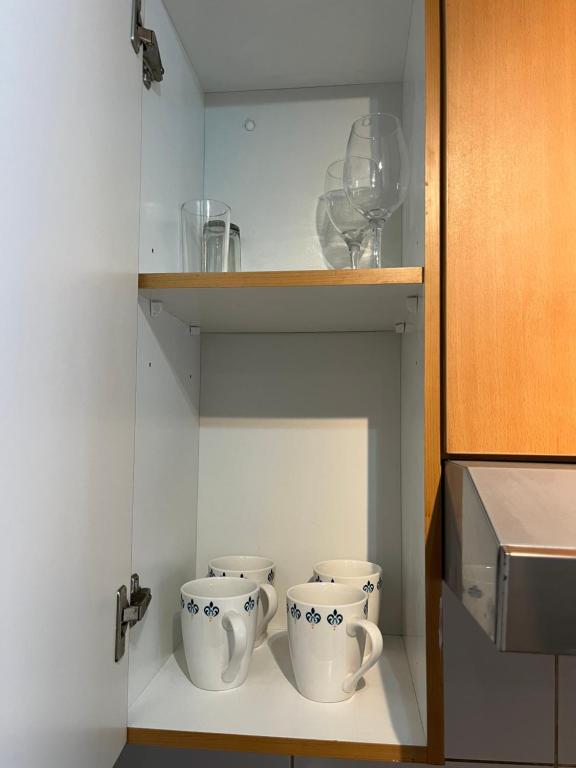 two cups sitting on a shelf in a kitchen at Amoblados GUSCAR in Santiago