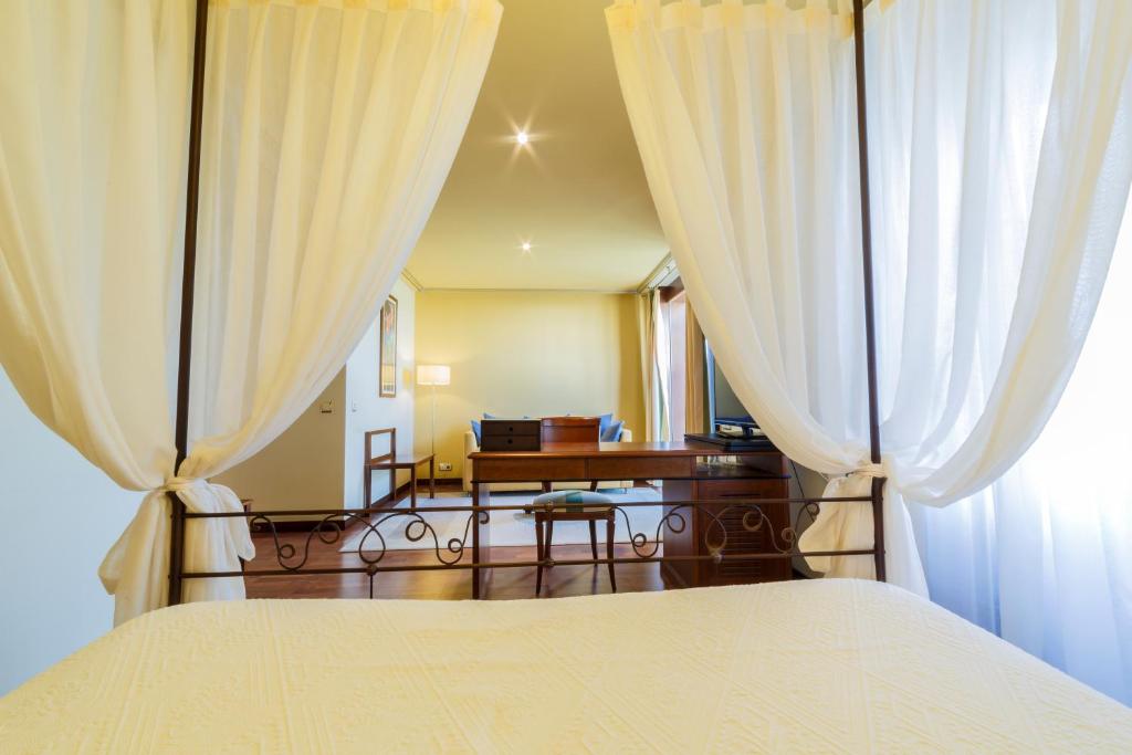 - une chambre avec un lit et des rideaux blancs dans l'établissement Hotel Azofra, à Burgos