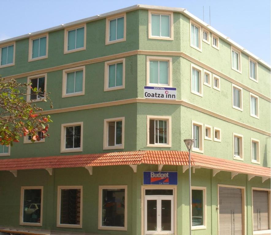 een groot groen gebouw met een bord erop bij Hotel Coatza Inn in Coatzacoalcos