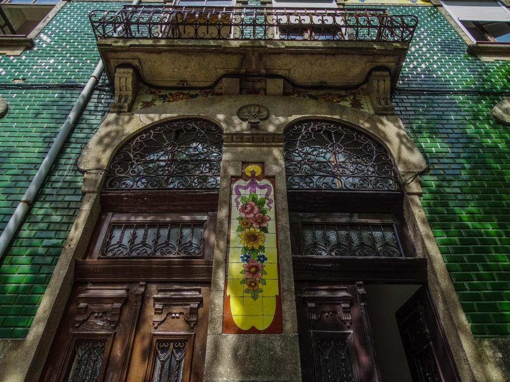 uma porta com dois vitrais num edifício em O2 Hostel no Porto