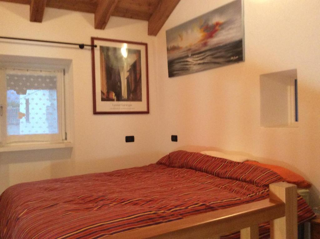 sypialnia z łóżkiem i oknem w obiekcie Chez Sylvie Vda-Issogne-001 w mieście Issogne