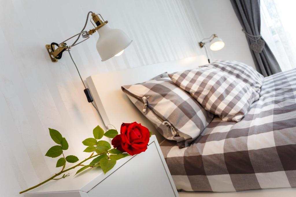 1 dormitorio con 1 cama y una rosa roja sobre una mesa en Apartments Mia, en Malinska