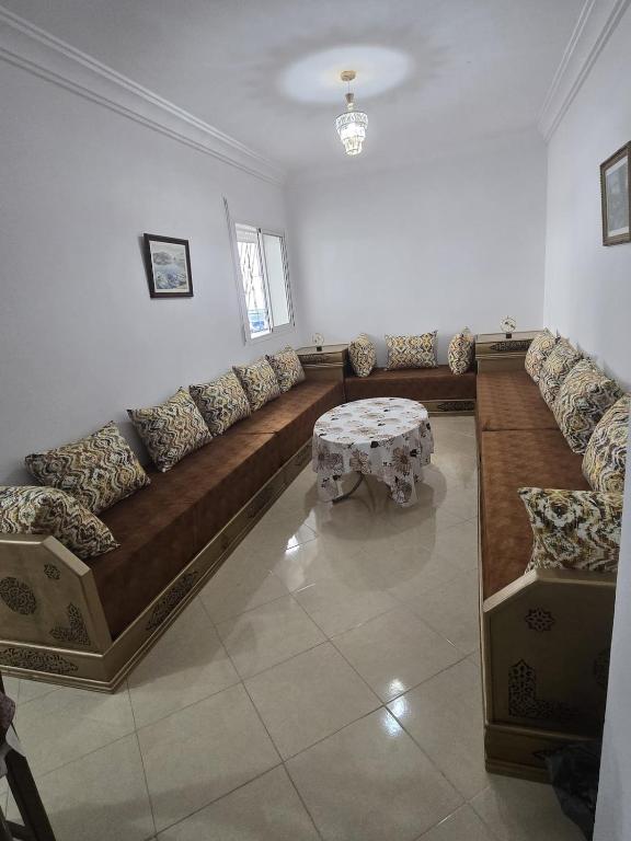 a living room with a long couch and a table at Martil Riad Sofia in Martil