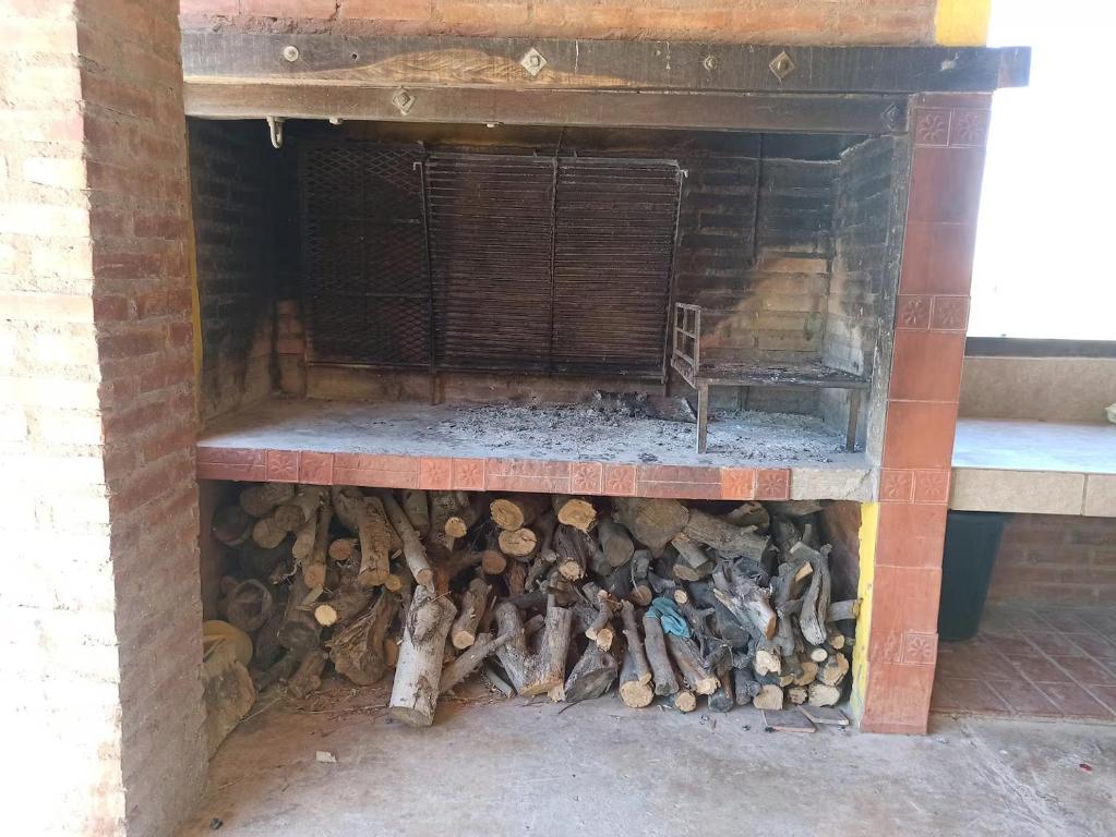 a pile of fire wood in a brick fireplace at Alala Campo Casa Quinta in Pocito