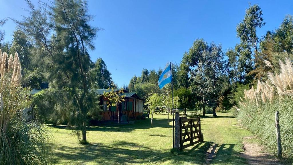 een houten hek in een tuin met een hut bij La Alegría in Alegre