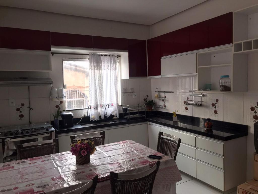 a kitchen with a table with chairs and a window at Cantinho da Gente in Belém