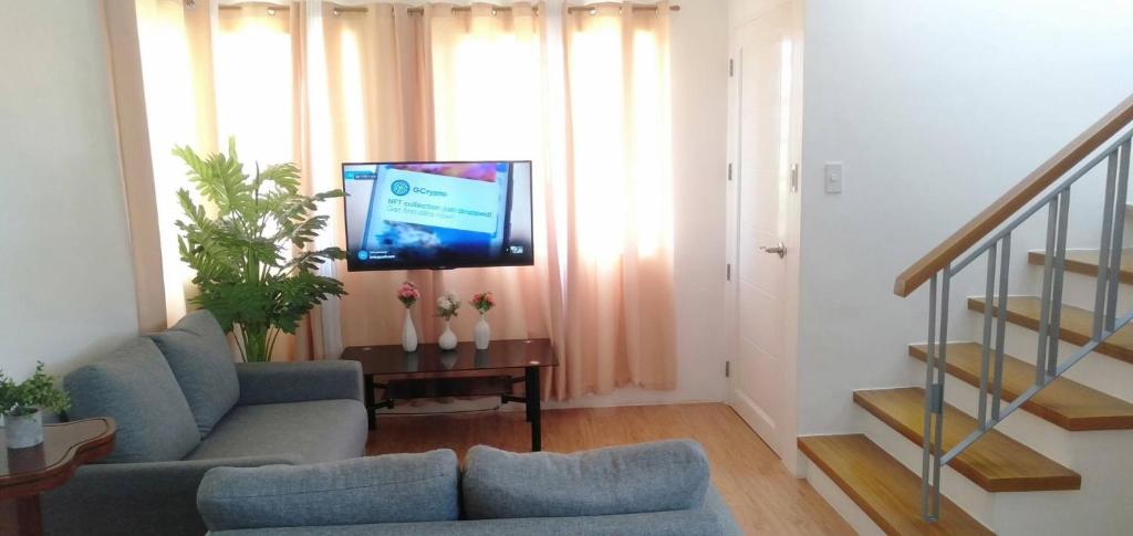 a living room with a couch and a flat screen tv at Avida 3-Bedroom Vacation House with Pool in Minuluang