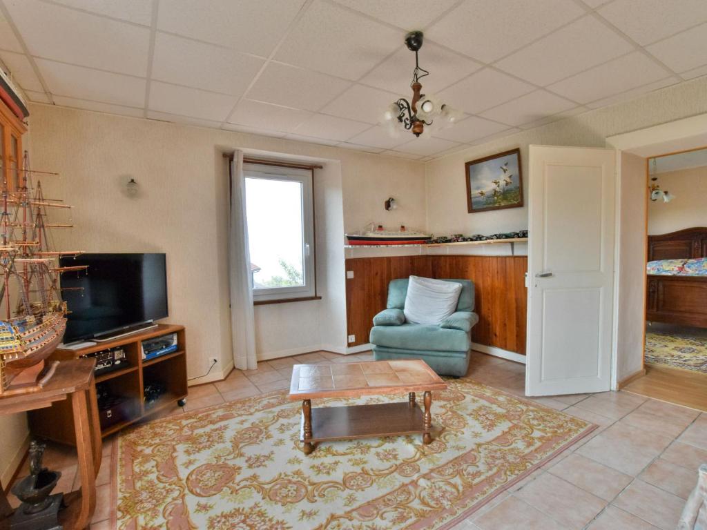 a living room with a tv and a couch and a table at Appartement à Neuvecelle avec balcon, parking et vue lac - FR-1-498-119 in Neuvecelle