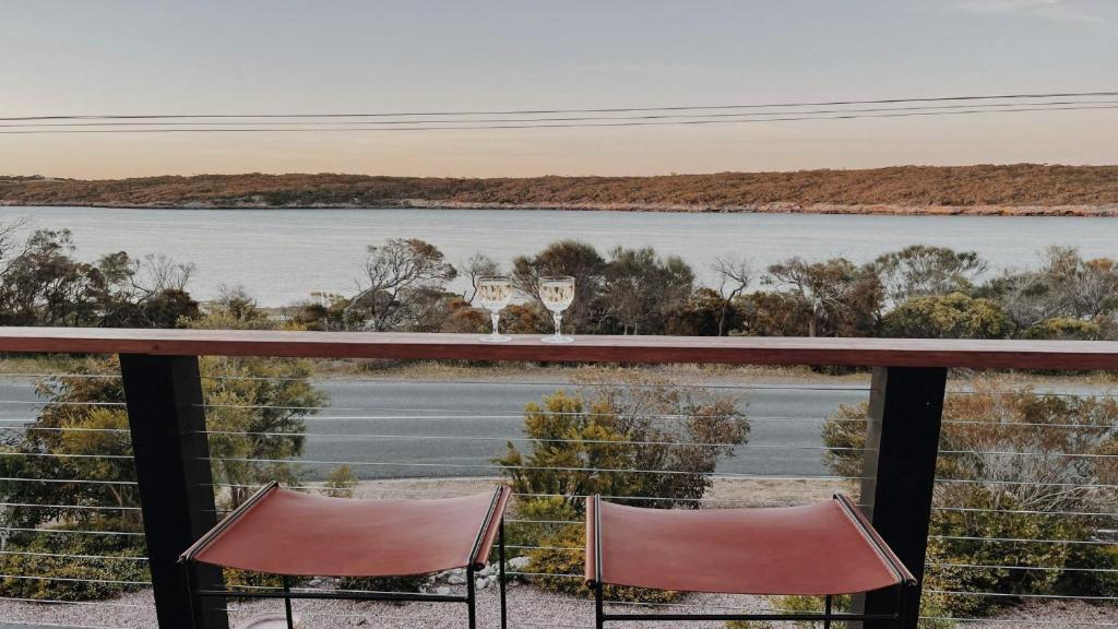 two chairs on a balcony with a view of the water at Dusk Coffin Bay in Coffin Bay