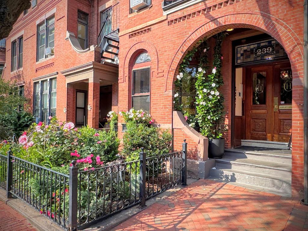 Una entrada a un edificio de ladrillo con una puerta de madera en Copley House, en Boston