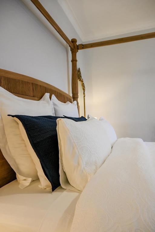 a bed with white and black pillows on it at Carisbrook Cottage in Armidale
