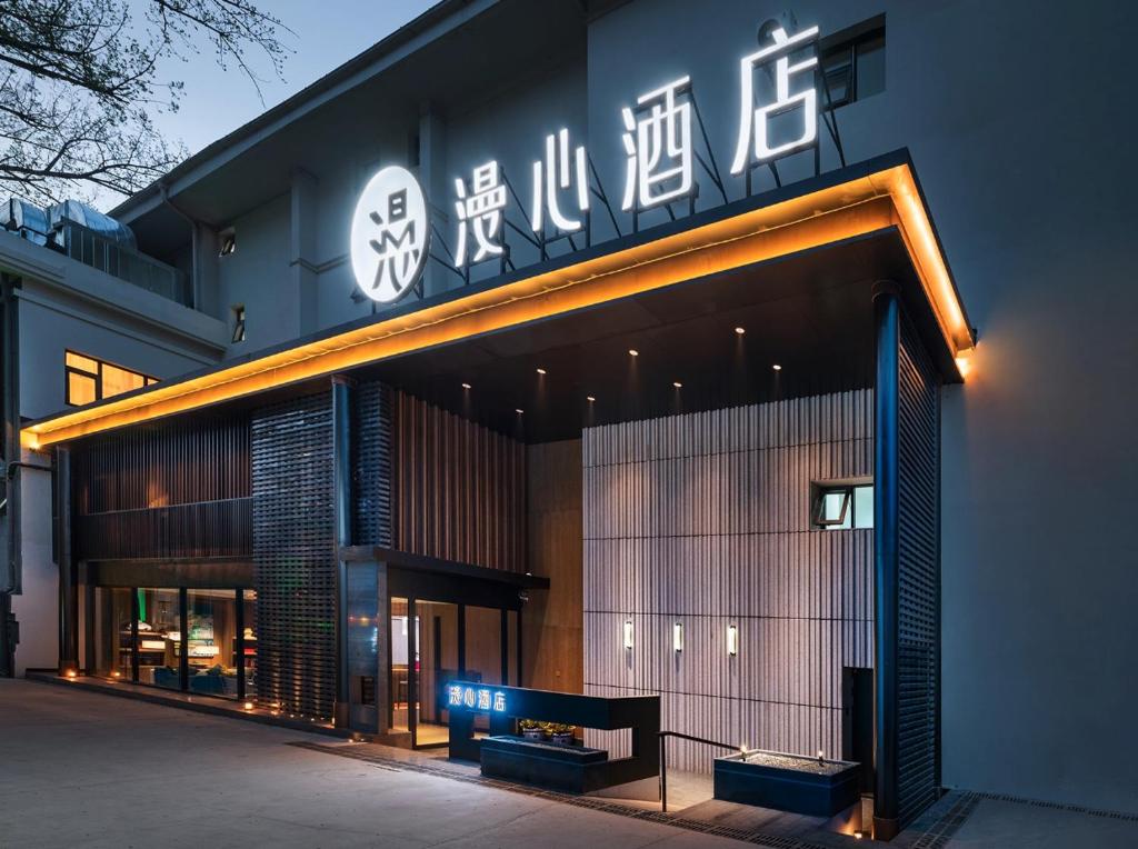 a building with a sign on the side of it at Manxin Hotel Beijing Lama Temple in Beijing