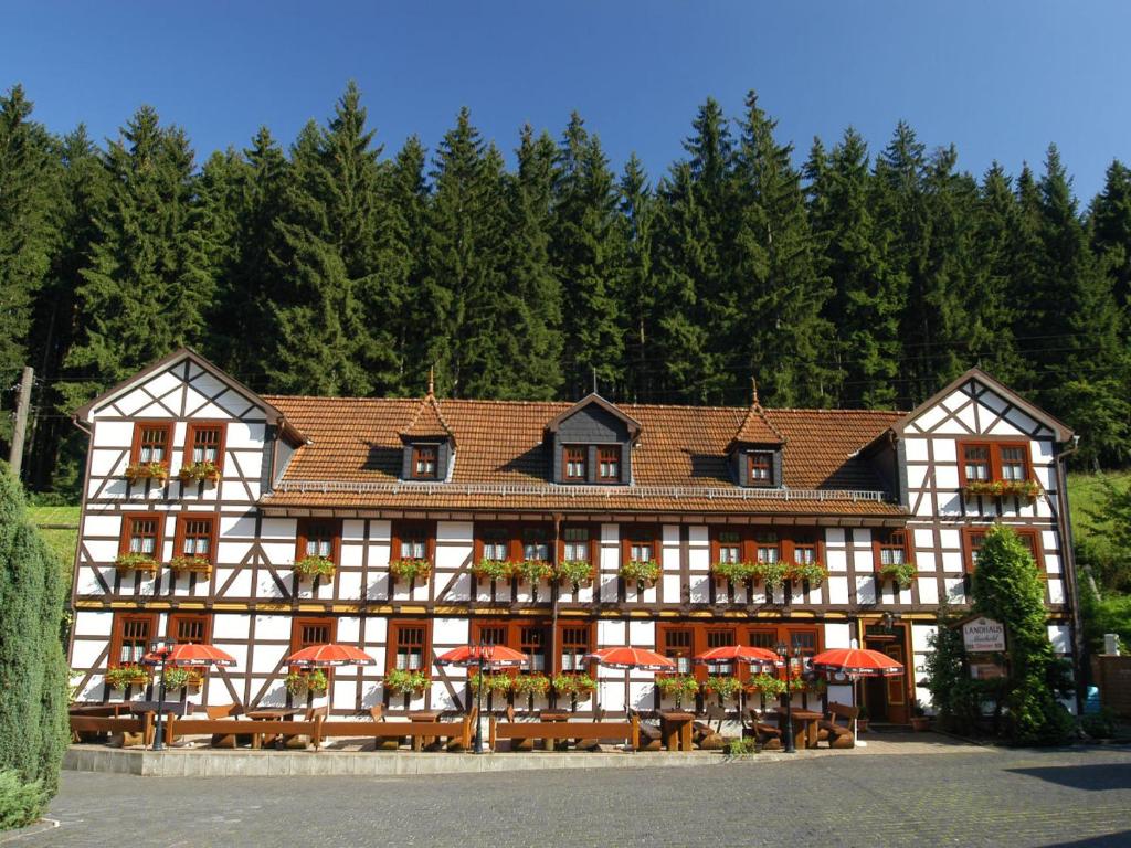 ein Gebäude mit roten Sonnenschirmen davor in der Unterkunft Pension Landhaus Machold in Friedrichroda