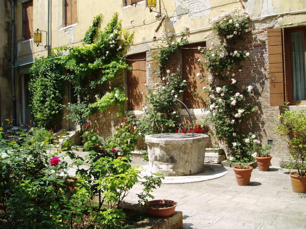 un jardín con flores y plantas frente a un edificio en Domus Ciliota en Venecia