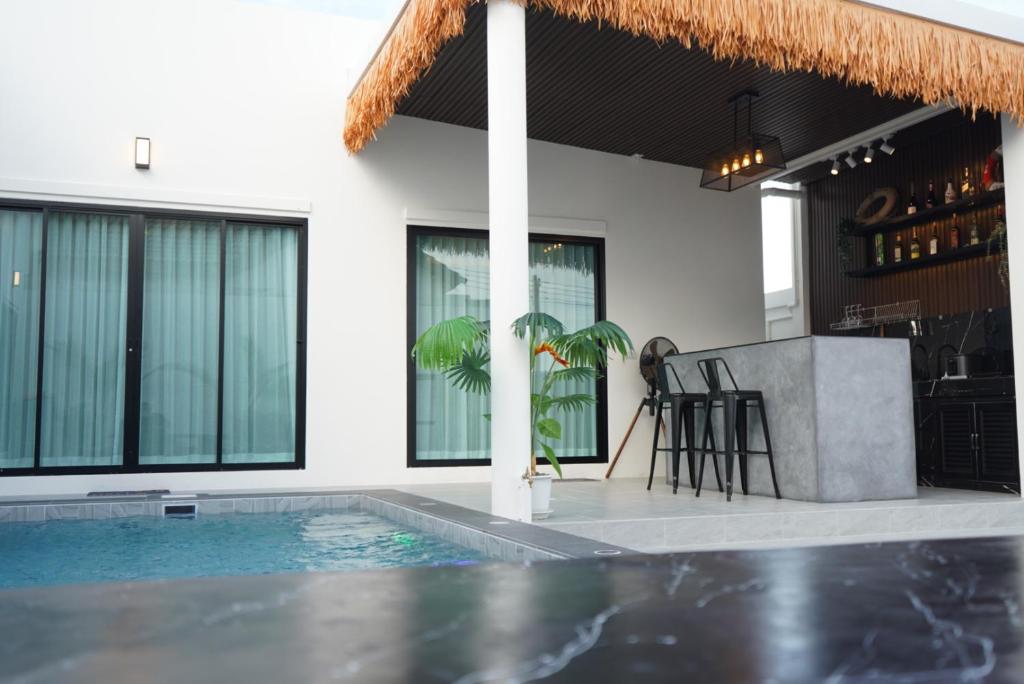 a villa with a swimming pool and a bar at Beloved Bliss Pool Villa Bangsaen in Chon Buri