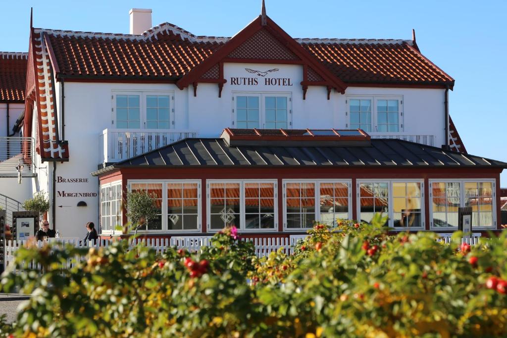 un grand bâtiment blanc avec un toit rouge dans l'établissement Ruths Hotel, à Skagen