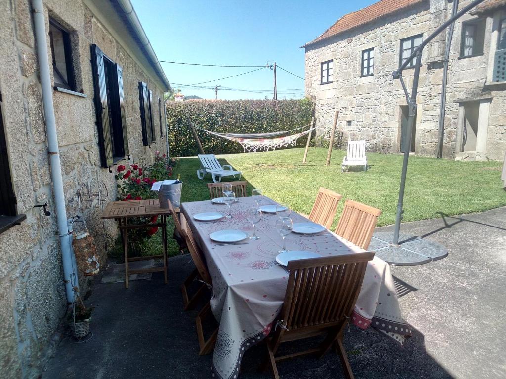 una mesa con platos y copas de vino en un patio en Quinta da Lage, en Barcelos