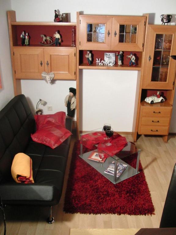 a living room with a black couch and a glass table at Ferienwohnung Anne in Sankt Ulrich am Pillersee
