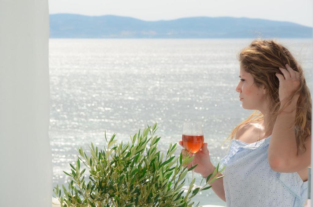 uma mulher está segurando um copo de vinho em Naxian Breeze em Agia Anna (Naxos)