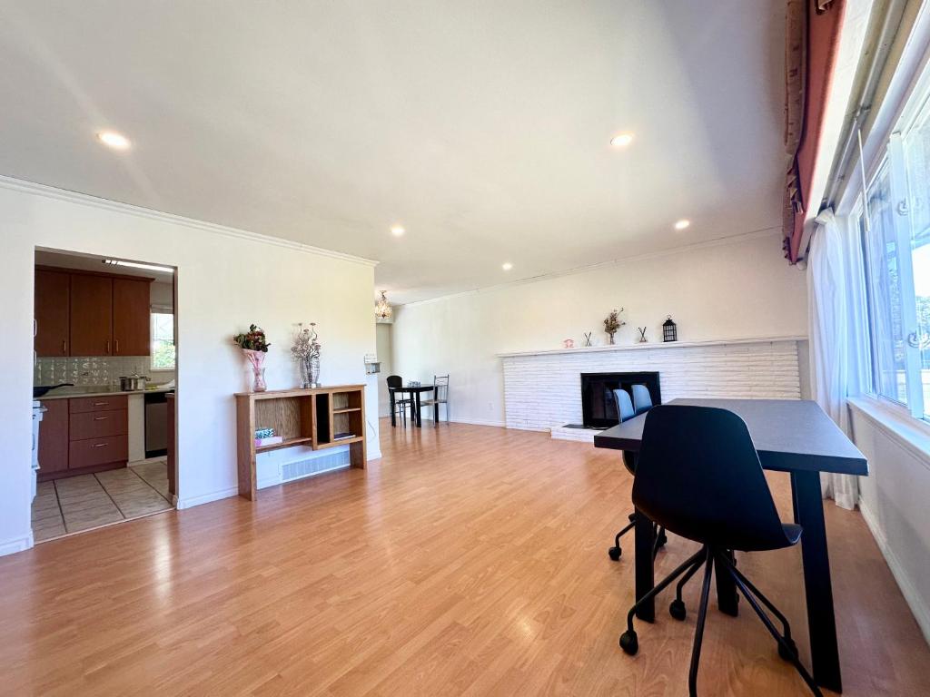 a kitchen and living room with a table and a fireplace at Spacious 4 Bedroom House Near YVR Airport, Transit & Shopping in Richmond