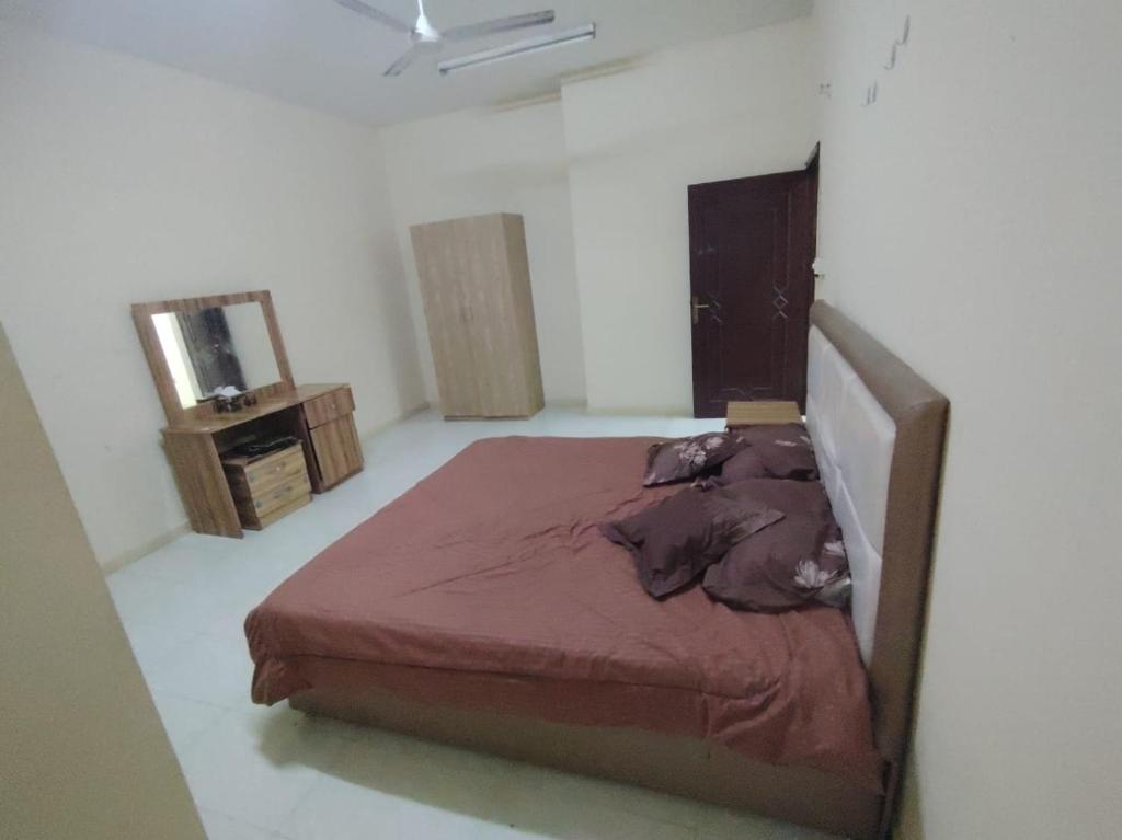 une chambre avec un lit, une commode et un miroir dans l'établissement شقة غرفتين وصاله وسط صلاله - Two-bedroom apartment in the center of Salalah, à Salalah