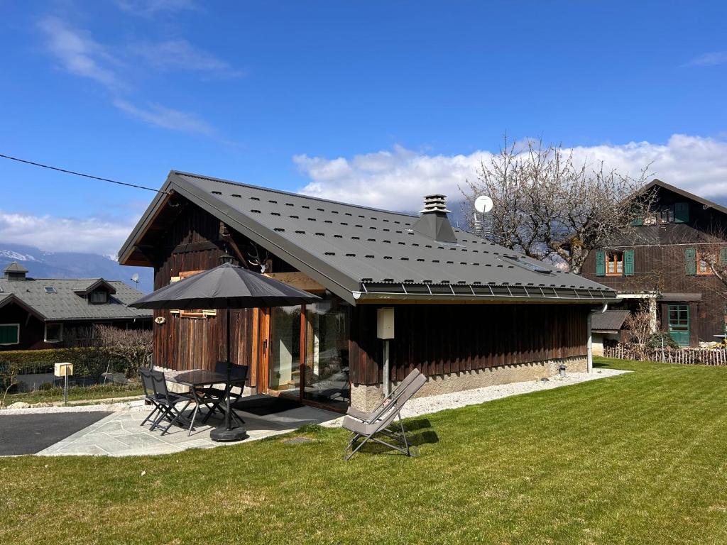 a house with a black roof and a table and chairs at Chalet Ulysse in Saint-Gervais-les-Bains