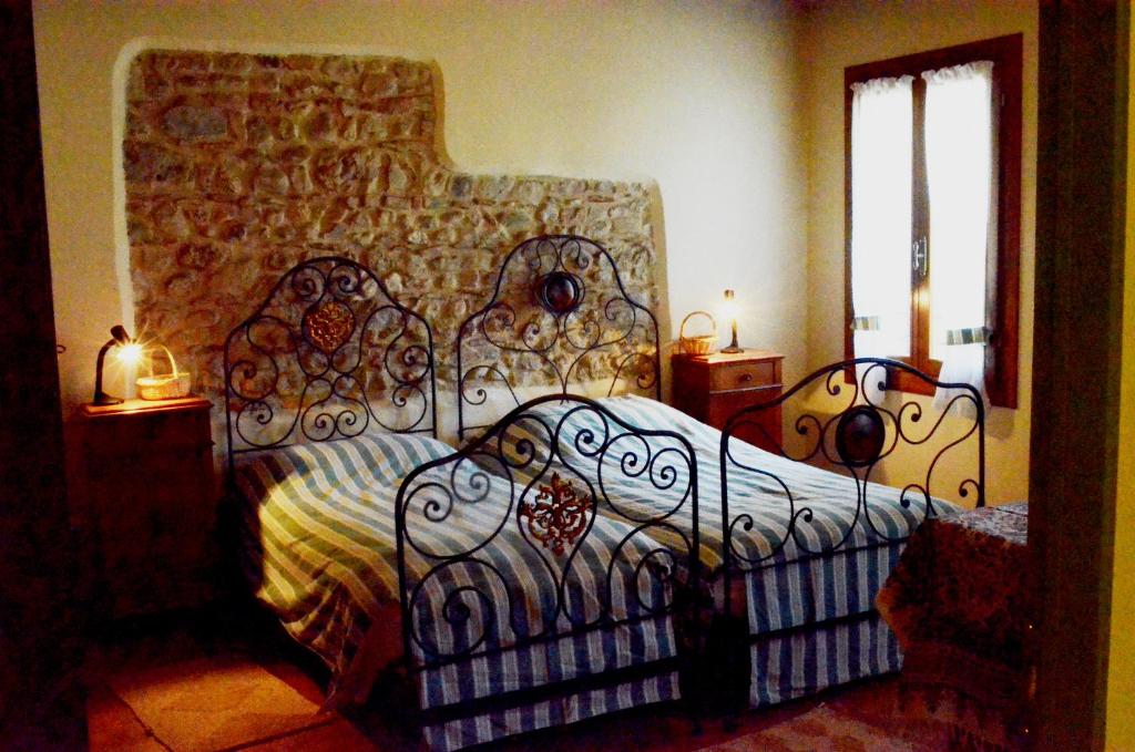 Schlafzimmer mit einem Bett mit einem schmiedeeisernen Rahmen in der Unterkunft agriturismo Cà Roer in San Zenone