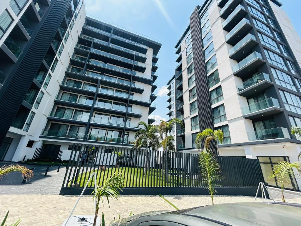 アクラにあるLuxury 1 bedroom at Novaのヤシの木が目の前に広がる高層ビル2棟