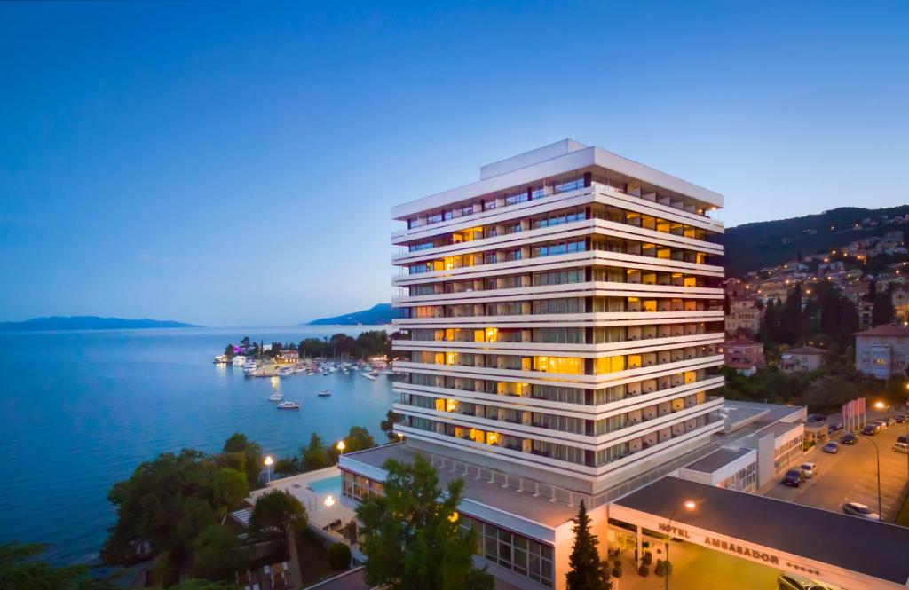 a tall white building next to a body of water at Hotel Ambasador - Liburnia in Opatija