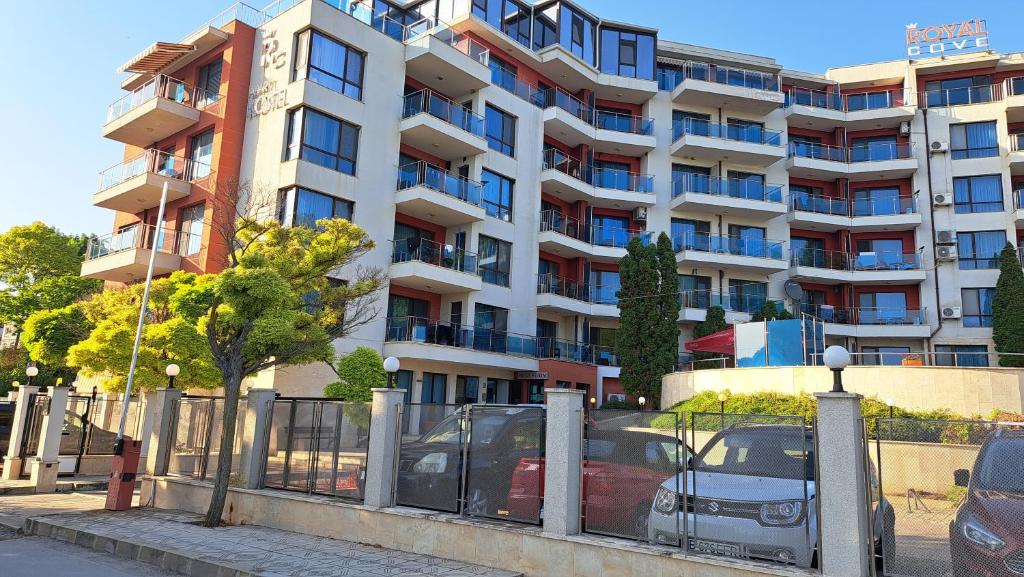 a large building with cars parked in front of it at Stefy Beach Apartment in Kavarna
