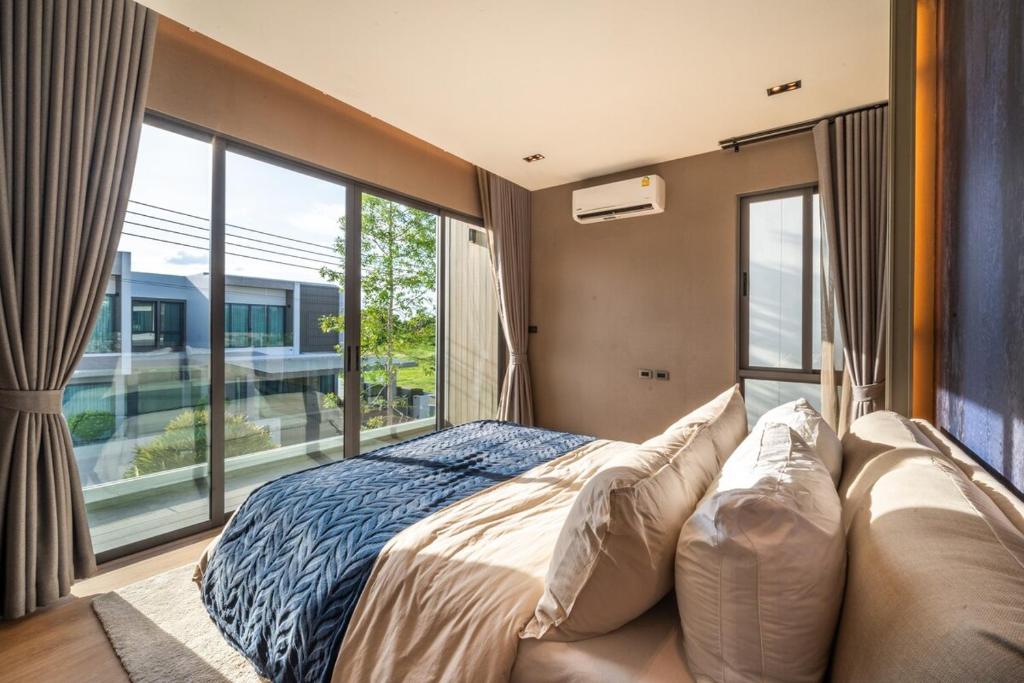 Ban Mae ChongにあるVanalux Garden Villa Chiangmaiのベッドと大きな窓のある寝室