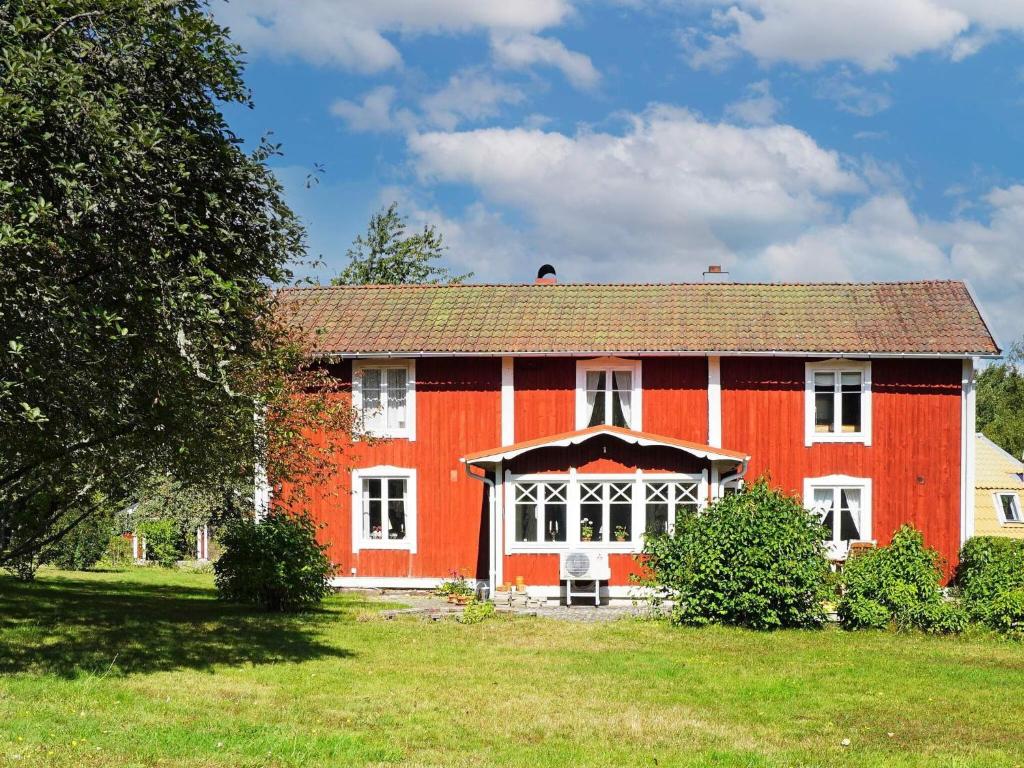 een groot rood huis met een grote tuin bij Idyllic Family Retreat Close to the Sea in Ronneby