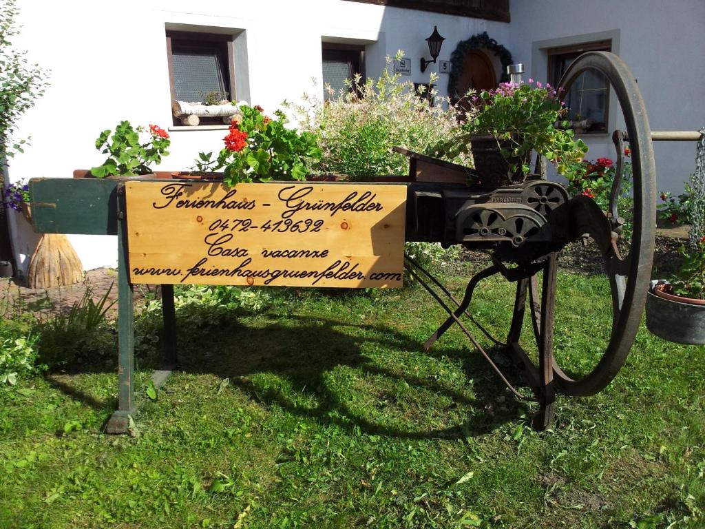 a sign in the grass in front of a house at Ferienhaus-Grünfelder in Luson