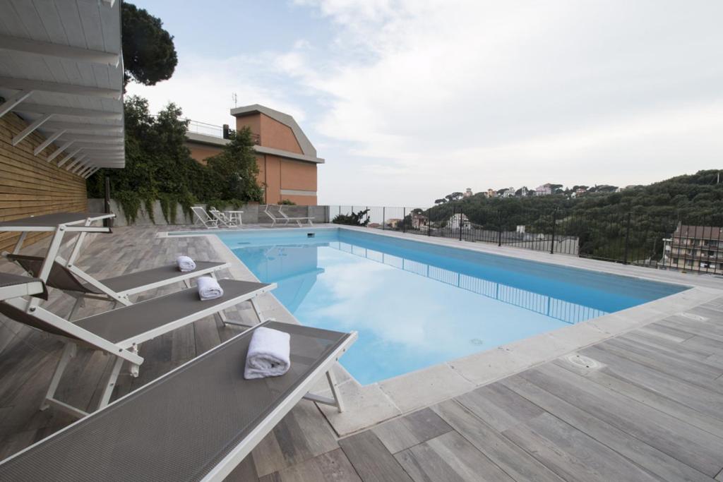 a swimming pool with two lounge chairs next to a building at Residence Felice in Celle Ligure