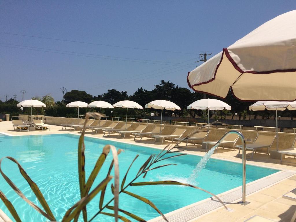 uma piscina com cadeiras e guarda-sóis em Tenuta I Quattro Venti em Otranto