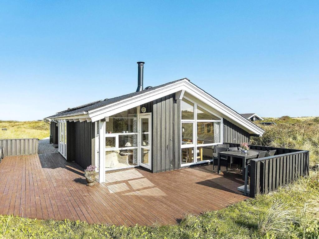 a house with a deck with a table on it at 8 person holiday home in Hjørring-By Traum in Kærsgård Strand