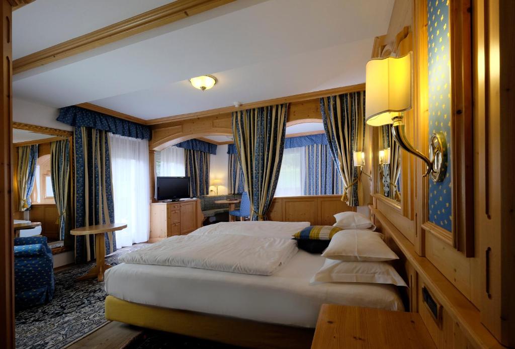 a bedroom with a large bed in a room at Hotel Evaldo in Arabba