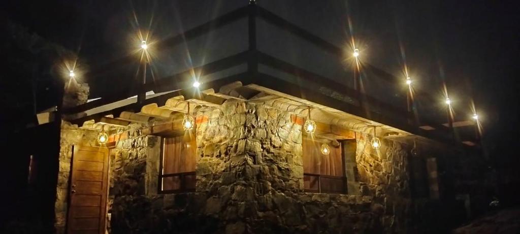 a stone building with lights on it at night at Nasaka jacala in Cuetzalán del Progreso