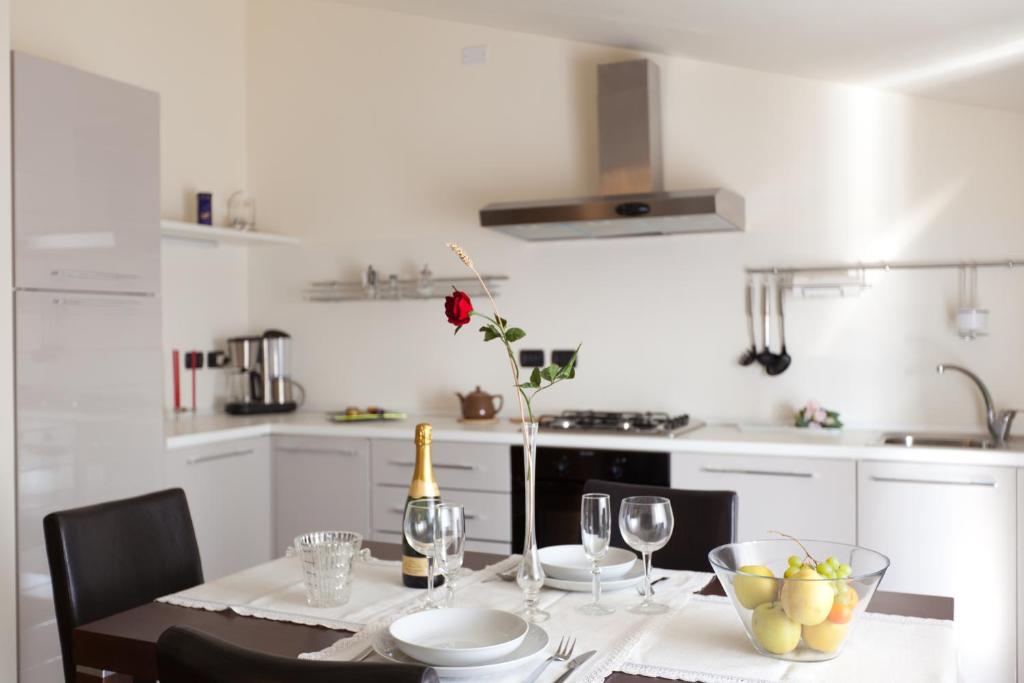 a white kitchen with a table with a bottle of wine at Residenza le Torri in Cavaion Veronese