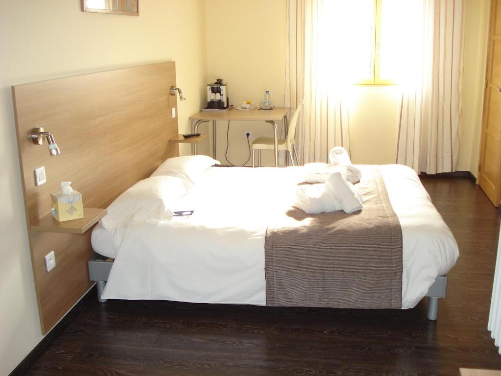 a hotel room with a bed with two teddy bears on it at La Tour Des Lys in Maubeuge